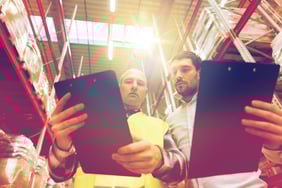 worker-and-businessmen-with-clipboard-at-warehouse-PSZHY4A